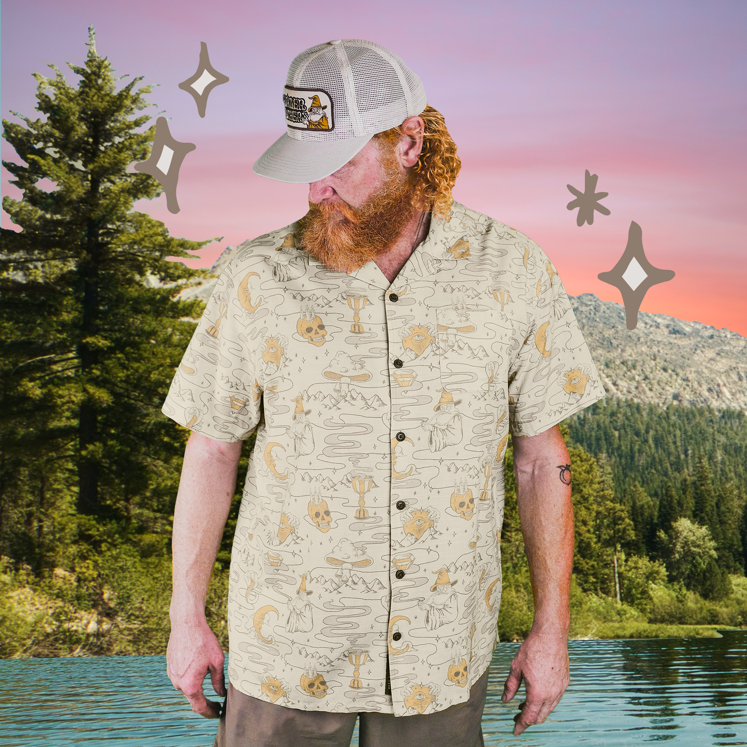A bearded man in a camp collar, patterned short-sleeve shirt and white cap stands by a lake with trees and mountains behind him, cartoon star shapes around. The sky glows pink and orange at sunset.