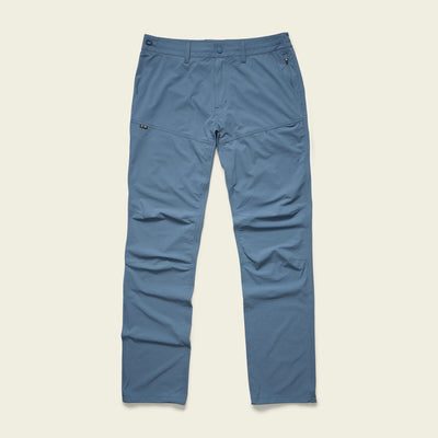 Blue straight-leg Tech Pants with 4-way stretch, front and side pockets, belt loops, and a zip fly, laid flat on a light background.