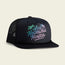 A black snapback cap with 'Los Hermanos' text and a palm tree graphic on the front, featuring a mesh back and a Howler monkey icon tag.
